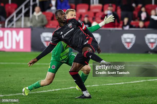 Christian Benteke of D.C. United watches the ball as he scores his third goal of the MLS game against Henrich Ravas of New England Revolution during...