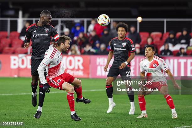 Christian Benteke of D.C. United heads the ball against Dave Romney of New England Revolution during the second half of the MLS game at Audi Field on...