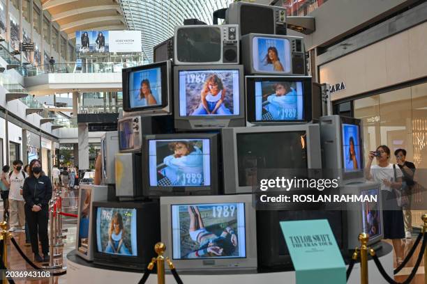 Fans of US singer Taylor Swift, also known as a Swifties, walk around an installation in the "Eras Tour Trail" that depicts different eras of the pop...