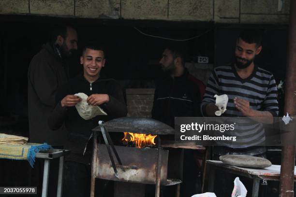 Palestinians bake bread on a upturned pan in the Al-Maghazi camp in central Gaza Strip, on Tuesday, Feb. 27, 2024. US President Joe Biden said...