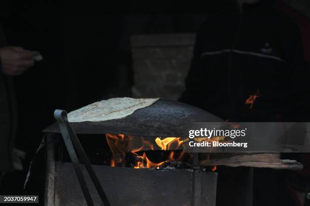 Palestinians bake bread on a upturned pan in the Al-Maghazi camp in central Gaza Strip, on Tuesday, Feb. 27, 2024. US President Joe Biden said...