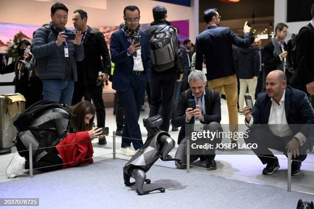 Visitors take pictures of the CyberDog 2 robot on Xiaomi's stand during the Mobile World Congress , the telecom industry's biggest annual gathering,...