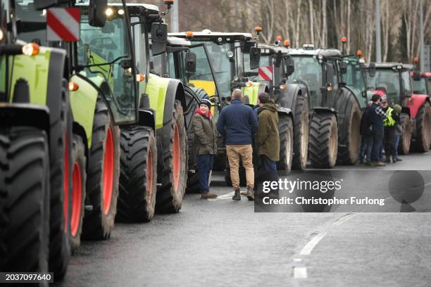 Farmers stand by their tractors as they wait to be directed to a holding area at the Queens Gate traffic Roundabout on February 28, 2024 in Cardiff,...