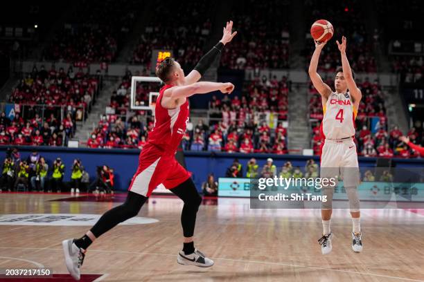 Jiwei Zhao of China shoots against Joshua Hawkinson of Japan during the FIBA Asia Cup qualifier Group C game between Japan and China at Ariake...