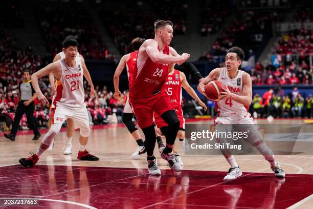 Jiwei Zhao of China drives against Joshua Hawkinson of Japan during the FIBA Asia Cup qualifier Group C game between Japan and China at Ariake...