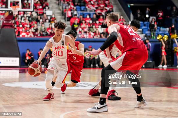 Jie Xu of China drives against Joshua Hawkinson of Japan during the FIBA Asia Cup qualifier Group C game between Japan and China at Ariake Coliseum...