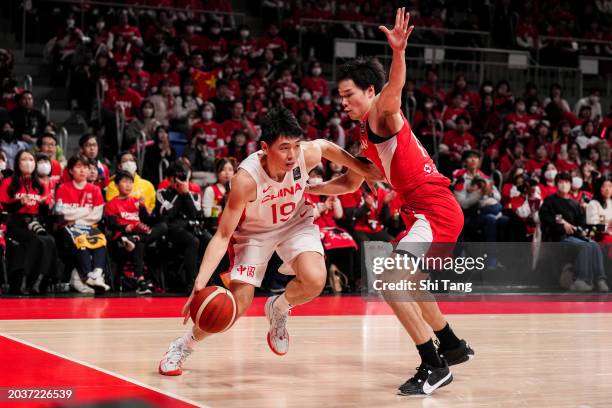 Yongxi Cui of China drives against Yudai Baba of Japan during the FIBA Asia Cup qualifier Group C game between Japan and China at Ariake Coliseum on...
