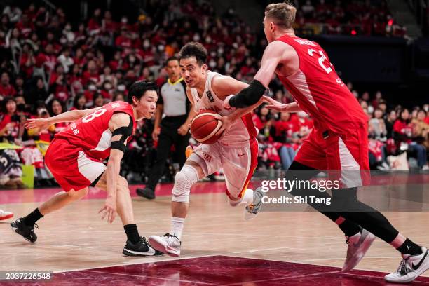 Jiwei Zhao of China drives against Joshua Hawkinson and Yudai Baba of Japan during the FIBA Asia Cup qualifier Group C game between Japan and China...