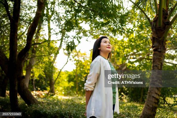 dreamy woman enjoying peaceful forest ambiance - ambiance girly stock pictures, royalty-free photos & images