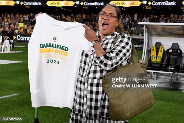 Australian Olympic gold medallist Cathy Freeman holds a t-shirt up after the women's football qualifying match for the 2024 Paris Olympic Games...
