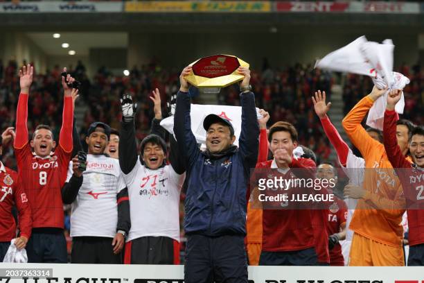 Head coach Yahiro Kazama of Nagoya Grampus lifts the J1 Promotion Play-Off Winners plaque at the award ceremony following the J.League J1 Promotion...