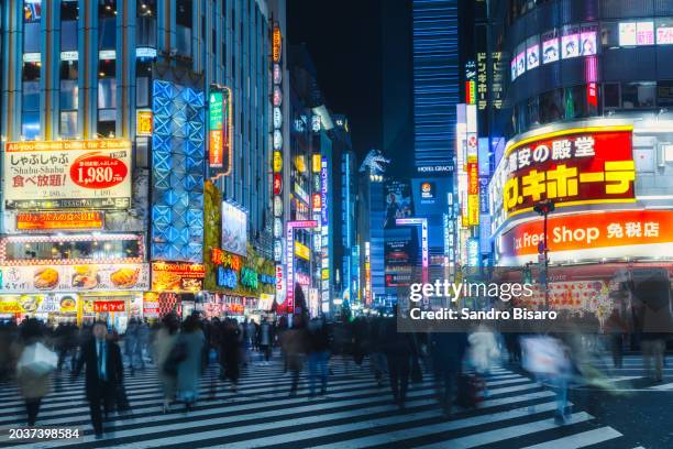 tokyo kabukicho entrance at night with blurred people crossing the street - tokyo prefecture stock pictures, royalty-free photos & images