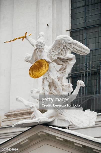 the statue of saint michael at the saint michael church (michaelerkirche) in vienna - archangel michael stock pictures, royalty-free photos & images