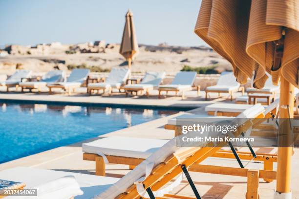 lounge chairs beside pool. - bordo piscina foto e immagini stock