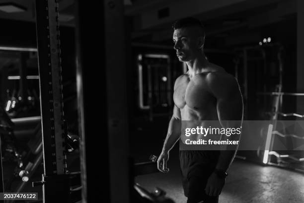 muscular young man lifting weights in the gym - black and white instant print stock pictures, royalty-free photos & images