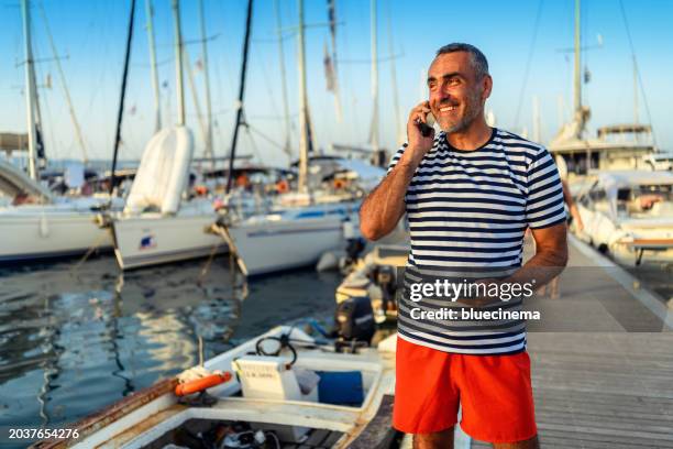 sailboat charter worker works in a harbor - charterboot stockfoto's en -beelden