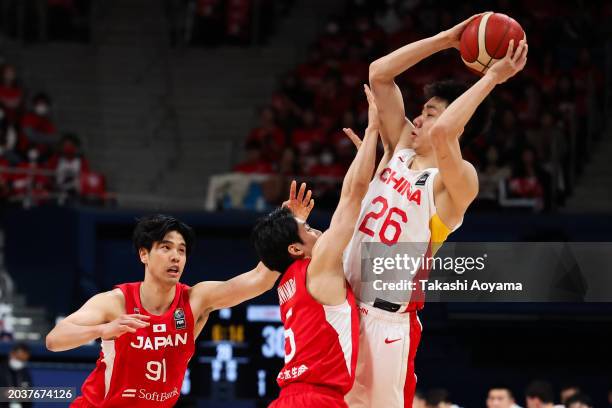 Junlong Zhu of China handles the ball against Hirotaka Yoshii and Yuki Kawamura of Japan during the FIBA Basketball Asia Cup qualifier Group C game...