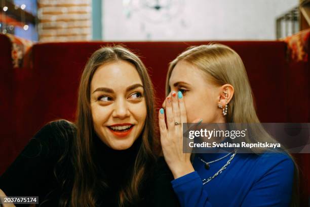 two cheerful girlfriends enjoying women's day in a restaurant - gossip stock pictures, royalty-free photos & images