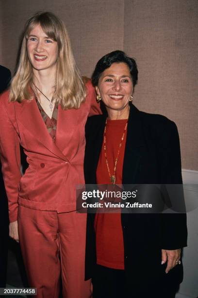 American actress Laura Dern, wearing a red trouser suit, with a pendant hanging from a bootlace necklace, and American politician Barbara Boxer,...