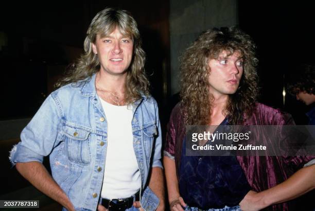 British singer, musician and songwriter Joe Elliott, wearing a denim jacket over a white t-shirt, and British musician Rick Savage, who wears a...