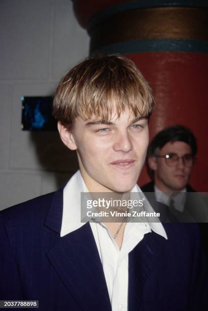 American actor Leonardo DiCaprio, wearing a white wide collar shirt beneath a black blazer, attends the Westwood premiere of 'The Basketball...