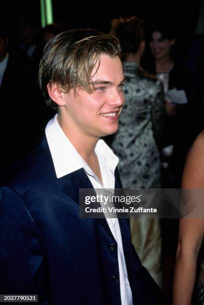 American actor Leonardo DiCaprio, wearing a white wide collar shirt beneath a black blazer, attends the Westwood premiere of 'The Basketball...