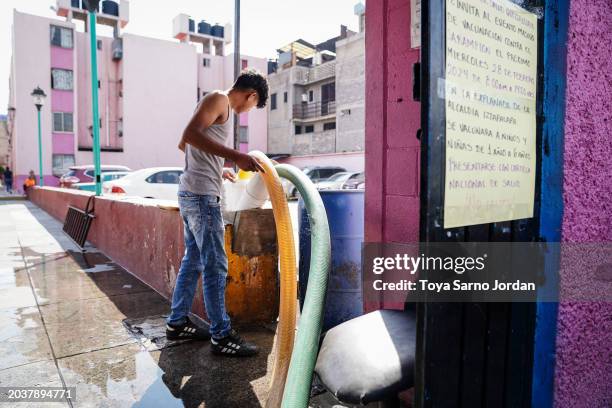 Worker connects a hose to a water tank at an apartment complex in the Las Peñas neighborhood in Iztapalapa on February 27, 2024 in Mexico City,...