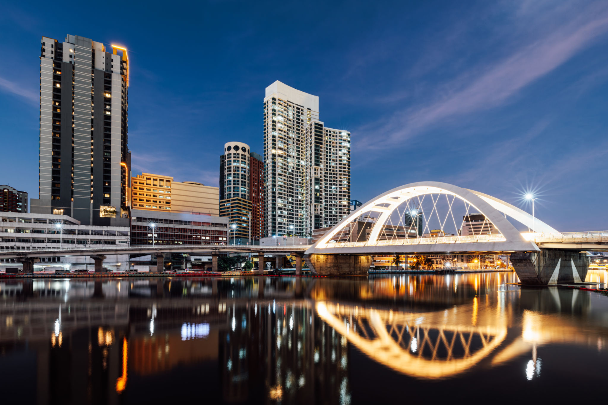 Manila City skyline during sunset with a bridge connecting Intramuros to Binondo area Manila City skyline during sunset with a bridge connecting Intramuros to Binondo area
