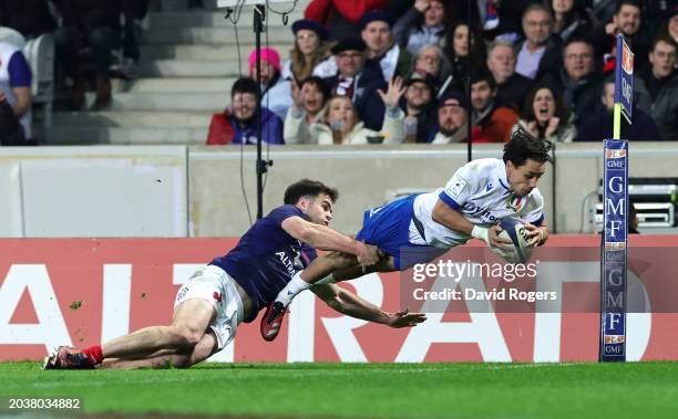 Ange Capuozzo of Italy breaks past Damian Penaud of France to score his team's first try during the Guinness Six Nations 2024 match between France...