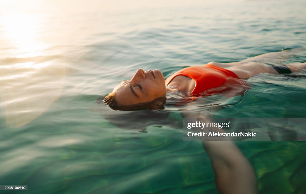 Mid adult woman swimming in the calm sea water
