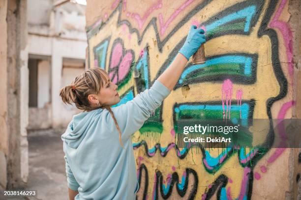 talented female artist draws colorful graffiti on the wall and creates her art - multi coloured glove stock pictures, royalty-free photos & images