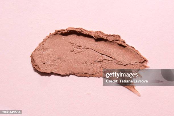 beige pastel colored lipstick swatch on trendy pink background. fashion, beauty products industry. macro photography, top view, close up - pink lipstick smear stock pictures, royalty-free photos & images