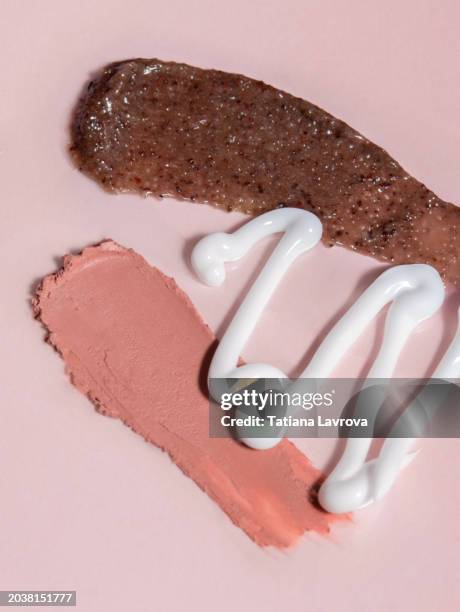 set of textured beauty products on pink background. brown body scrub, white face cream, lipstick swatch for healthy skin - pink lipstick smear stock pictures, royalty-free photos & images