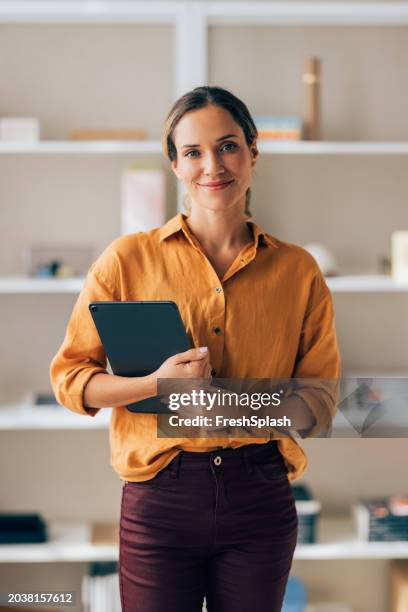confident professional woman holding tablet in modern office - roupa descontraída imagens e fotografias de stock