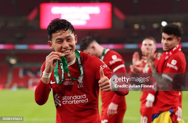 Wataru Endo of Liverpool bites his medal after the team's victory in the Carabao Cup Final match between Chelsea and Liverpool at Wembley Stadium on...
