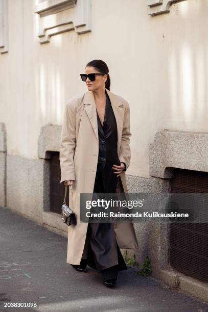 Gili Biegun wears black wide pants, a black long leather vest, a beige coat, and a silver and black Valentino bag outside Chiara Boni La Petite Robe...