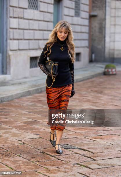 Ekaterina Mamaeva wears black pullover Raey, rust brown skirt Anine Bing, heels The Row, bag Celine, necklace Chloe, transparent laced gloves...