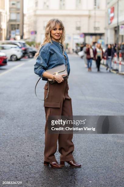 Ekaterina Mamaeva wears denim shirt Chloe, brown pants Peter Do, shoes By Far, grey bag Celine, earrings By Pariah, necklace Tiffany & Co outside...