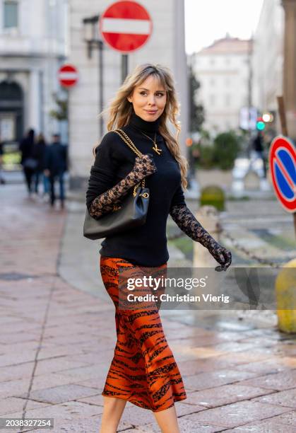 Ekaterina Mamaeva wears black pullover Raey, rust brown skirt Anine Bing, bag Celine, necklace Chloe, transparent laced gloves Calzedonia outside...