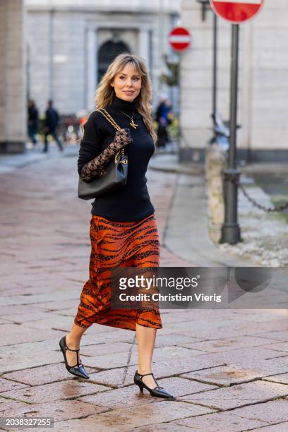 Ekaterina Mamaeva wears black pullover Raey, rust brown skirt Anine Bing, heels The Row, bag Celine, necklace Chloe, transparent laced gloves...