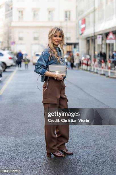 Ekaterina Mamaeva wears denim shirt Chloe, brown pants Peter Do, shoes By Far, grey bag Celine, earrings By Pariah, necklace Tiffany & Co outside...