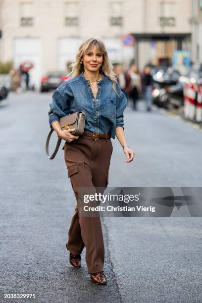 Ekaterina Mamaeva wears denim shirt Chloe, brown pants Peter Do, shoes By Far, grey bag Celine, earrings By Pariah, necklace Tiffany & Co outside...