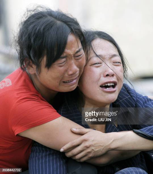 Mother and another relative grieve over her dead boy outside of a collapsed elementary school in Yingxiu of Wenchuan county, after a quake with a...