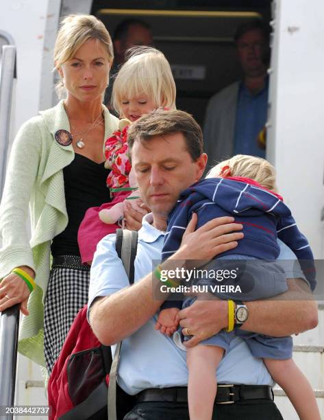 The parents of missing toddler Madeleine McCann, Kate and Gerry carry their two-year-old twin children Sean and Amelie as they arrive back in Britain...