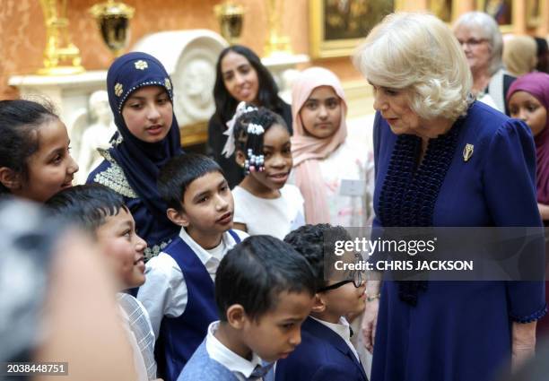Britain's Queen Camilla speaks with children during a reception for the BBC's 500 Words Finalists at Buckingham Palace on February 28, 2024 in London.