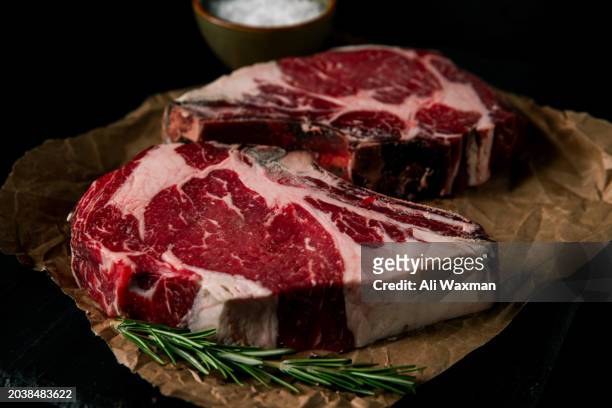 two raw dry aged rib eye steaks - entrecôte stockfoto's en -beelden