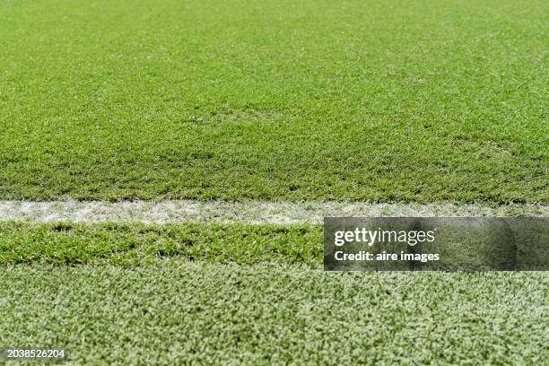 slightly high angle view of a white line on a green soccer field of the stadium without people - soccer field outline stock pictures, royalty-free photos & images