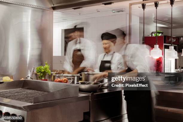 motion blurred chefs cooking meals - crowded kitchen stock pictures, royalty-free photos & images