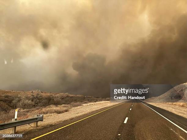 In this handout photo provided by the Texas A&M Forest Service, smoke billows over a road during the Smokehouse Creek fire on February 27, 2024 in...