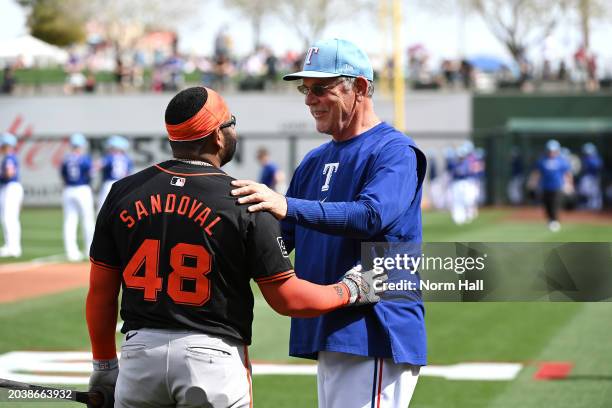 Manager Bruce Bochy of the Texas Rangers talks with Pablo Sandoval of the San Francisco Giants prior to a spring training game at Surprise Stadium on...